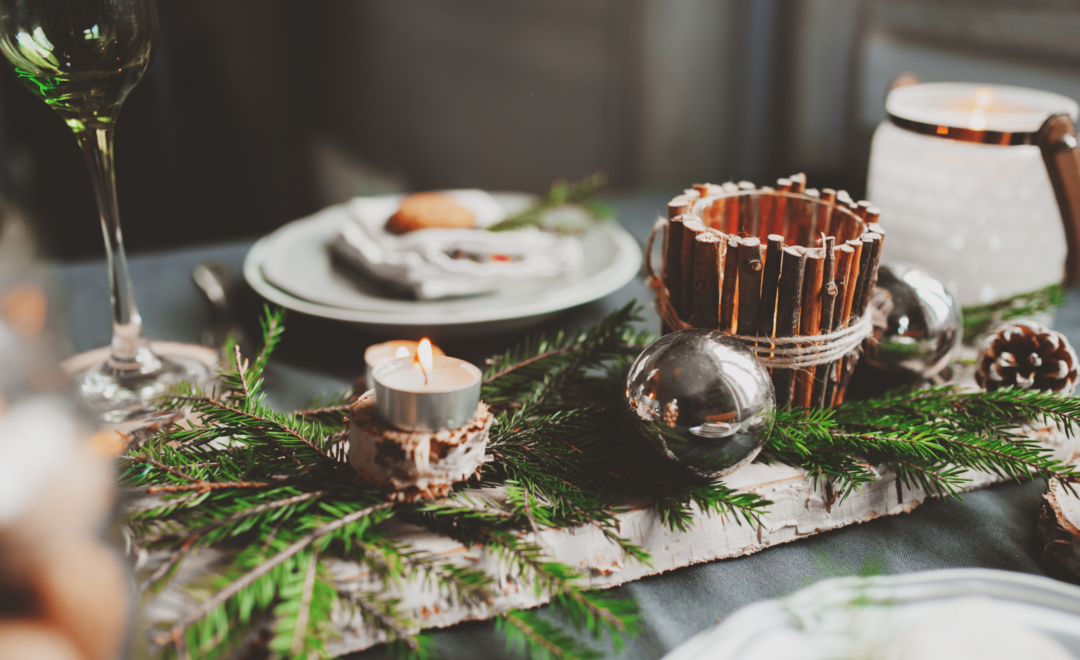 holiday platesetting with plate, glass, pinetree branches and pinecones