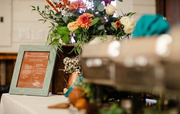 Teal menu sign on a buffet with flowers and chafers