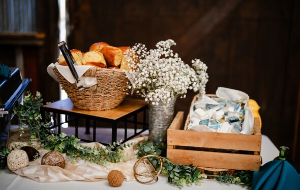 Bread baseket, flowers and butter on wedding buffet