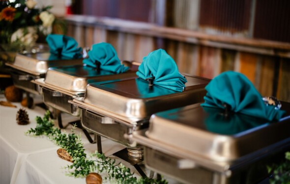 Chafers on a buffet with fancy teal napkins