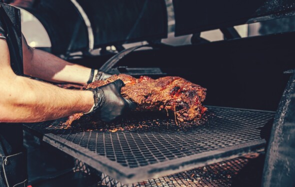 chef placing meat on smoker